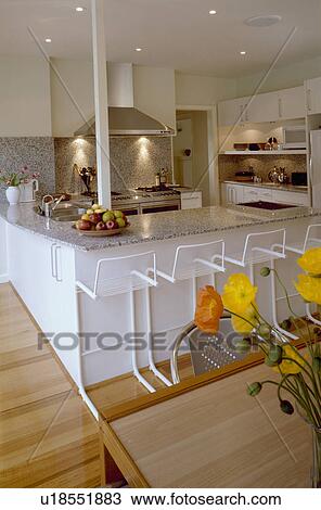White stools at granite-topped breakfast bar in modern white kitchen View Large Photo Image Stock Image - White stools at granite-topped breakfast bar in modern white kitchen. Fotosearch