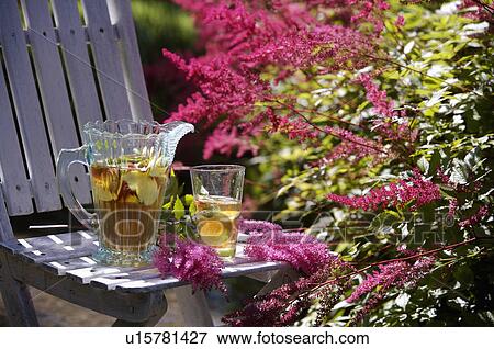 Stock Photo - White table and chairs in grassy corner of rough mown lawn.. Fotosearch