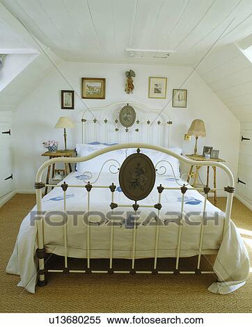 Stock Photography - White wrought iron bed in white bedroom. Fotosearch
