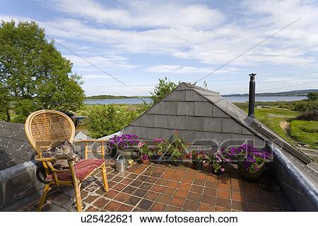 Wicker chair on roof garden of cottage with view of lake View Large Photo Image Stock Image - Wicker chair on roof garden of cottage with view of lake. Fotosearch
