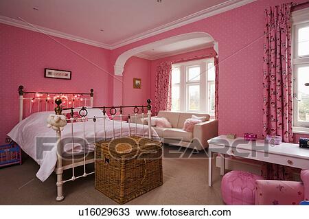 Wicker chest below antique white metal bed in traditional bedroom with pink wallpaper View Large Photo Image Stock Image - Wicker chest below antique white metal bed in traditional bedroom with pink wallpaper. Fotosearch