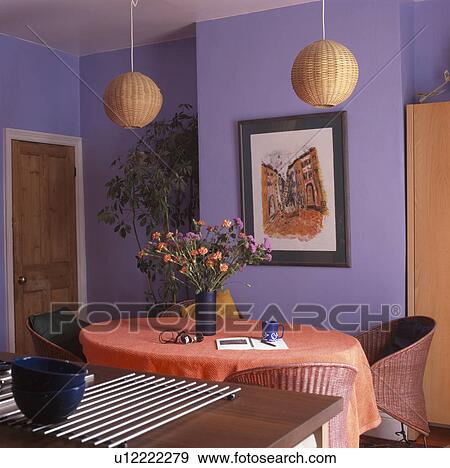 Wicker lights above table with orange cloth in blue dining room View Large Photo Image Stock Photo - Wicker lights above table with orange cloth in blue dining room. Fotosearch