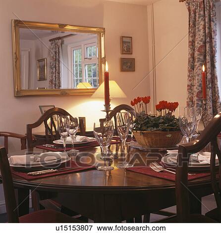 Wineglasses and place settings on table in traditional dining room with rectangular gilt mirror View Large Photo Image Stock Photo - Wineglasses and place settings on table in traditional dining room with rectangular gilt mirror. Fotosearch