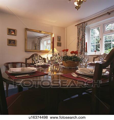 Wineglasses and place settings on table in traditional dining room with rectangular gilt mirror View Large Photo Image Stock Photo - Wineglasses and place settings on table in traditional dining room with rectangular gilt mirror. Fotosearch