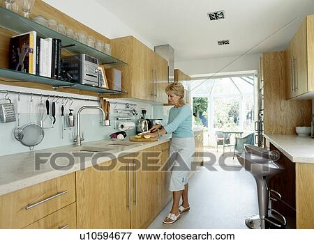 Woman chopping lemons in modern kitchen View Large Photo Image Stock Photo - Woman chopping lemons in modern kitchen. Fotosearch