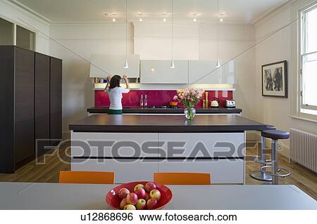 Stock Photograph - Woman cooking in modern kitchen. Fotosearch