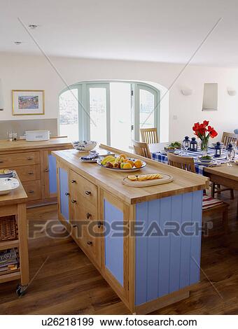 Wood worktop on blue island unit used as divider between open-plan coastal kitchen and dining room View Large Photo Image Stock Photo - Wood worktop on blue island unit used as divider between open-plan coastal kitchen and dining room. Fotosearch