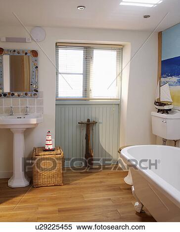 Wooden flooring and rolltop bath in white coastal bathroom with pale green panelling below window View Large Photo Image Stock Photography - Wooden flooring and rolltop bath in white coastal bathroom with pale green panelling below window. Fotosearch
