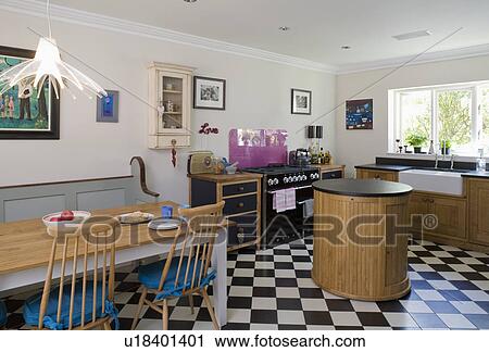 Wooden table and chairs in kitchen with circular island unit and black+white chequerboard flooring View Large Photo Image Stock Image - Wooden table and chairs in kitchen with circular island unit and black+white chequerboard flooring. Fotosearch