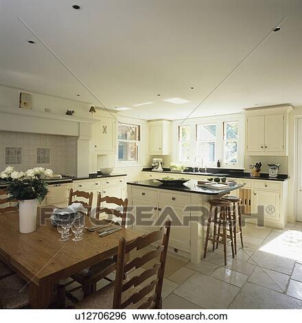 Wooden Table And Ladderback Chairs In Cream Country Kitchen With