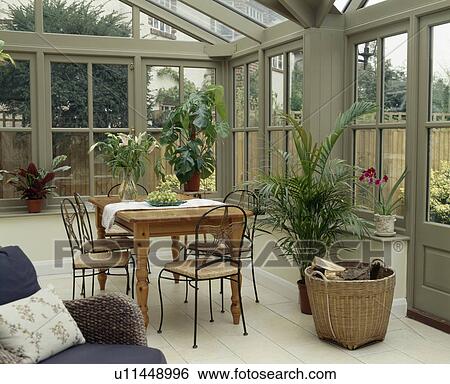 Wooden table and metal chairs in conservatory dining room View Large Photo Image Stock Photograph - Wooden table and metal chairs in conservatory dining room. Fotosearch