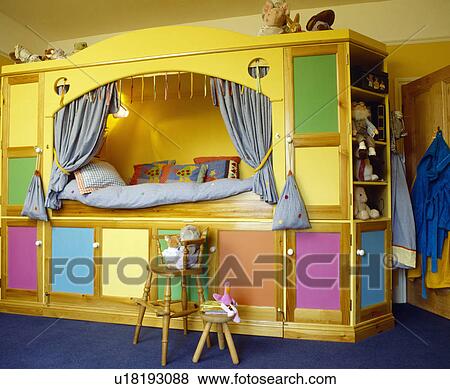 Yellow built-in platform bed with colourful doors on under-bed storage in child's bedroom View Large Photo Image Stock Photo - Yellow built-in platform bed with colourful doors on under-bed storage in child's bedroom. Fotosearch