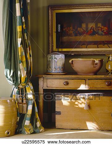 Stock Photography - Yellow+green checked curtain beside pine chest and table. Fotosearch