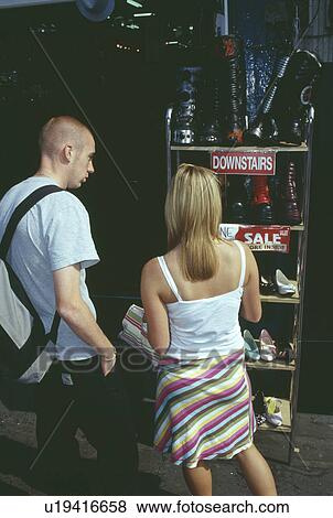 Young couple at stall outside shoe shop in Camden Town in London View Large Photo Image Stock Photo - Young couple at stall outside shoe shop in Camden Town in London. Fotosearch