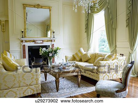 クリーム ブロケード ソファー そして Glass Topped コーヒーテーブル 中に クリーム パネルで飾られた 図画 部屋 で 薄い 緑 カーテン ストックイメージ U Fotosearch