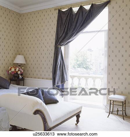 青い絹 カーテン 上に 高い 窓 中に 伝統的である 寝室 で 白 骨董品 Chaiselongue そして 壁紙をパターン装飾した ストックイメージ U Fotosearch
