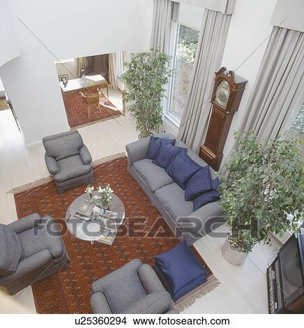 Picture - Aerial view of eighties living room with grey sofa and armchairs and tall houseplants. Fotosearch