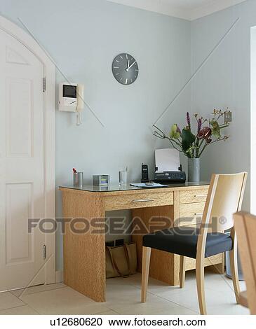 Stock Image - Answerphone on pale wood desk with matching chair in pastel blue home office. Fotosearch