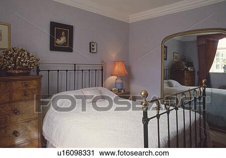 Antique brass bed and Victorian gilt mirror in mauve bedroom View Large Photo Image Stock Image - Antique brass bed and Victorian gilt mirror in mauve bedroom. Fotosearch