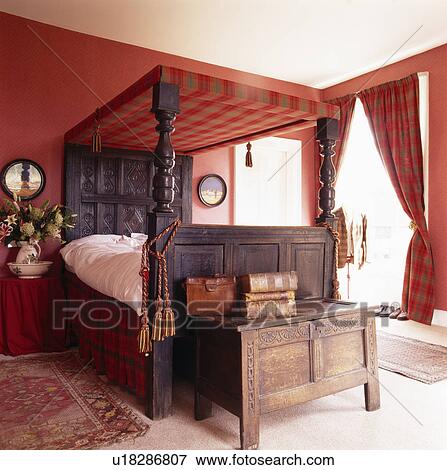 Antique chest and four-poster bed in red bedroom View Large Photo Image Stock Photo - Antique chest and four-poster bed in red bedroom. Fotosearch