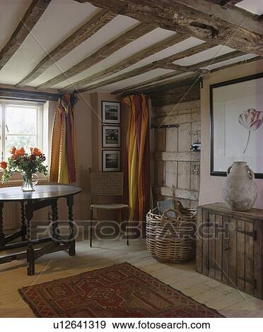 Stock Photo - Antique table and beamed ceiling in cottage hall. Fotosearch