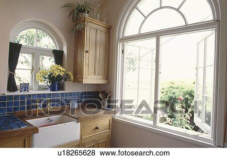 Arched casement window in fitted pine kitchen with white butlers sink View Large Photo Image Stock Photo - Arched casement window in fitted pine kitchen with white butlers sink . Fotosearch