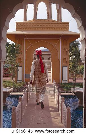 Back view of man in traditional Rajastani clothes crossing footbridge over water at Rajvilas Hotel View Large Photo Image Stock Photography - Back view of man in traditional Rajastani clothes crossing footbridge over water at Rajvilas Hotel. Fotosearch