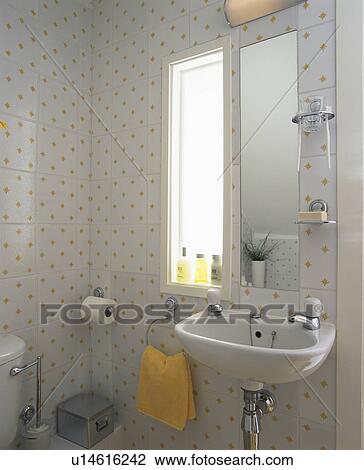 Stock Image - Basin in small white+yellow tiled attic bathroom. Fotosearch