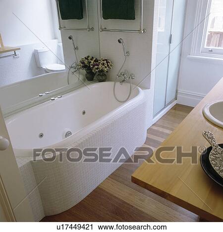 Stock Image - Bath with white mosaic surround in modern white bathroom. Fotosearch