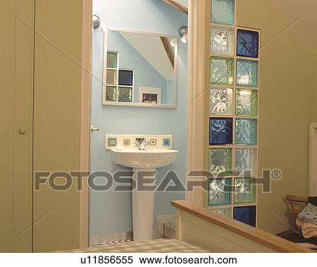 Bedroom door open to ensuite bathroom with mirror above white pedestal basin and green and blue glass bricks in wall View Large Photo Image Stock Photography - Bedroom door open to ensuite bathroom with mirror above white pedestal basin and green and blue glass bricks in wall. Fotosearch