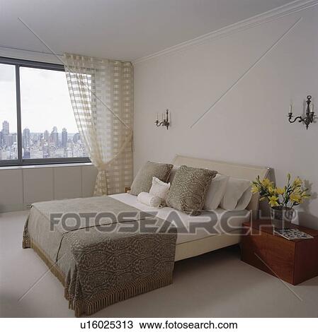 Beige and cream bedlinen on bed in modern city bedroom View Large Photo Image Stock Image - Beige and cream bedlinen on bed in modern city bedroom. Fotosearch