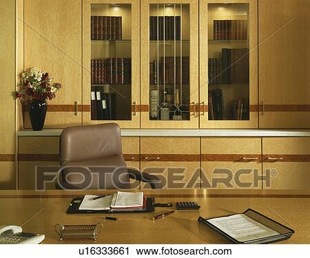 Beige leather chair at desk in traditional office with fitted pale wood bookcase View Large Photo Image Stock Image - Beige leather chair at desk in traditional office with fitted pale wood bookcase. Fotosearch