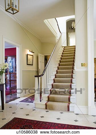 Stock Photo - Beige sisal carpet edged with red in traditional cream hall with cream+black tiled floor . Fotosearch