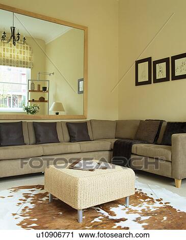Stock Image - Beige sofa unit in modern living room with animal-skin rug. Fotosearch