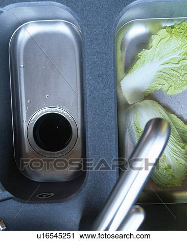 Stock Image - Birdseye close-up of stainless steel tap and double sink. Fotosearch