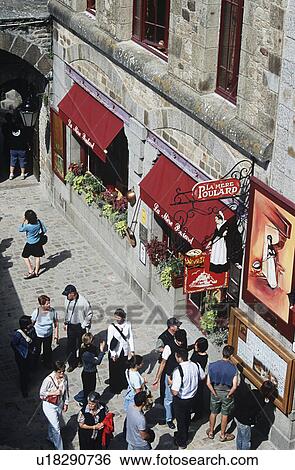 Stock Photograph - Birdseye view of tourists walking outside La Mere Poulard Restaurant, Le Mont Saint Michel, Normandy, France. Fotosearch