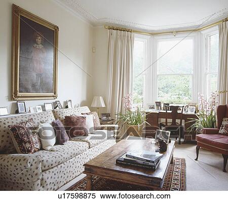 Stock Photography - Black and white spotted sofa and wooden coffee table in traditional neutral living room . Fotosearch
