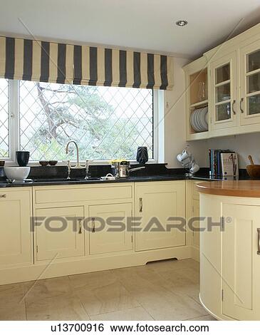 Black and white striped blind on window in country kitchen with cream fitted units painted in Farrow+Ball paint View Large Photo Image Stock Photograph - Black and white striped blind on window in country kitchen with cream fitted units painted in Farrow+Ball paint. Fotosearch