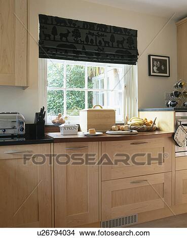 Black blind on window in kitchen with beech fitted units View Large Photo Image Picture - Black blind on window in kitchen with beech fitted units. Fotosearch