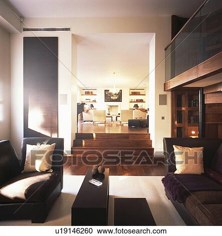 Stock Image - Black chaiselongues in modern white living room with split-level floor. Fotosearch