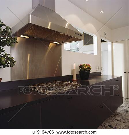 Black fitted unit with stainless steel hob in modern white kitchen View Large Photo Image Stock Photograph - Black fitted unit with stainless steel hob in modern white kitchen. Fotosearch