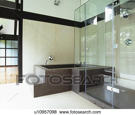 Stock Photo - Black granite bath in modern bathroom with glass shower cabinet. Fotosearch