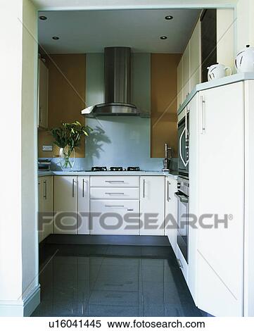 Stock Photography - Black granite flooring in modern kitchen with fitted white units. Fotosearch