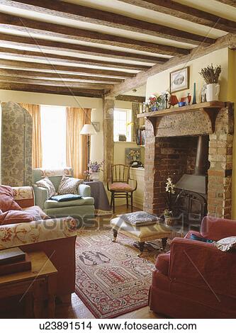 Picture - Black iron stove in cottage living room with beamed ceiling. Fotosearch