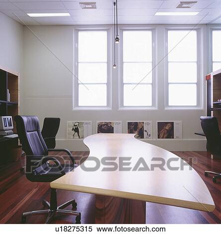 Black Leather Chair And Curved Desk In Modern Office Stock