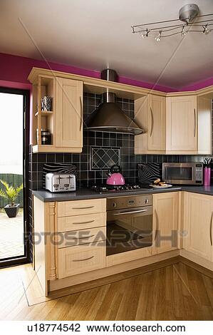 Black wall tiles above hob and oven in modern beech kitchen with wooden flooring View Large Photo Image Stock Image - Black wall tiles above hob and oven in modern beech kitchen with wooden flooring. Fotosearch