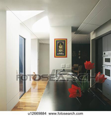 Picture - Black worktop on long fitted unit in modern kitchen. Fotosearch