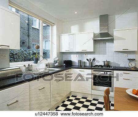Black+white chequerboard flooring in modern white kitchen View Large Photo Image Stock Photo - Black+white chequerboard flooring in modern white kitchen. Fotosearch