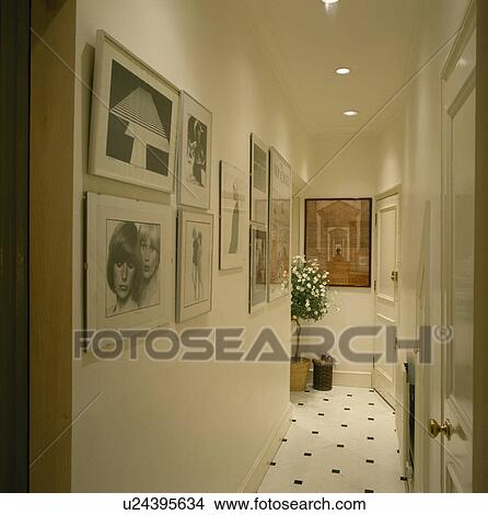 Picture - Black+white photographs on wall of modern white hall. Fotosearch