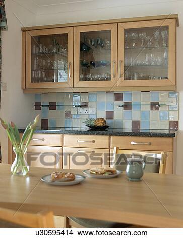 Blue And Cream Wall Tiles Below Glazed Cupboards In Traditional